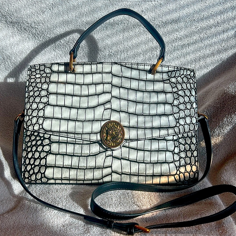 White and black handbag with unicorn embellishment with gold colored hardware